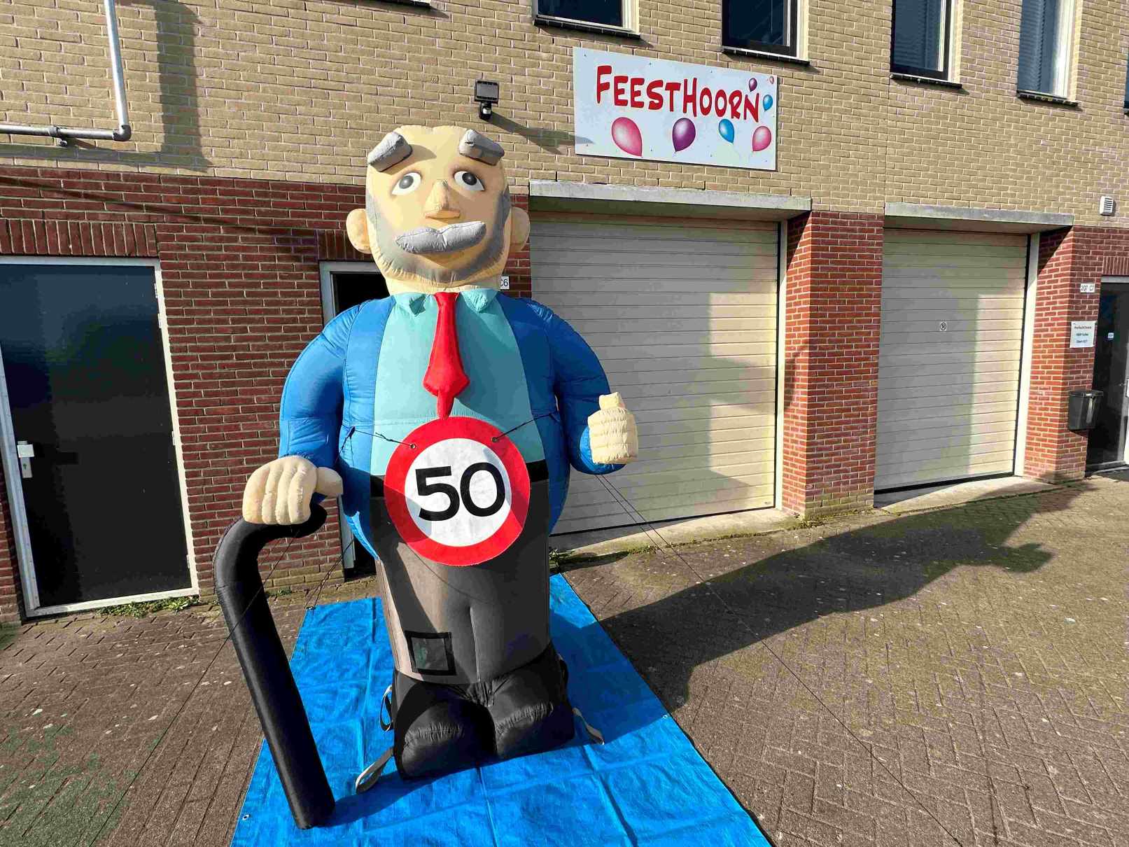 De Abraham L pop is 2,8 meter hoog met een wandelstok. Deze pop wordt standaard geleverd met een ’50’ verkeersbordbanner. Er is eventueel ook keuze uit een ander getal of een ‘pensioen’ banner.