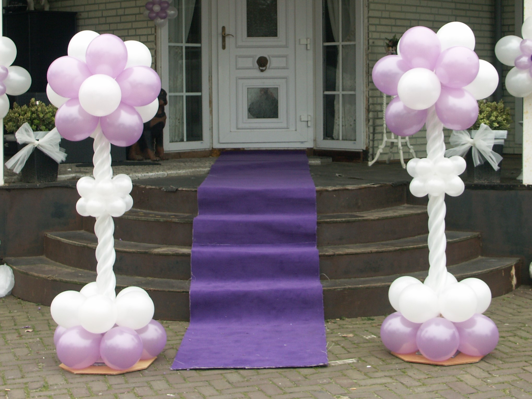 Ballonpilaren met modeleerballonnen in de stam en clusters ballonnen boven, midden en onder.